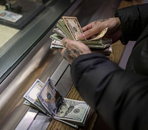 A man pays cash bail in the bond office to secure his brother’s release on Dec. 21, 2022, at the Cook County Jail in Chicago.
