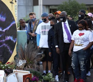 Attorney Ben Crump places his hands on the shoulders Tamika Palmer, Breonna Taylor's mother, as as she looks at a mural of her daughter on September 25, 2020 in Louisville, Kentucky.