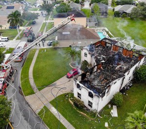 The scene of a house fire and shooting Monday in Osceola County, Fla. Officials say a man fired from inside the burning home, striking his neighbors and a fire department rescue vehicle. The man was later found dead.
