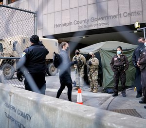 Pedestrians are cleared one at a time through one gate outside the Hennepin County Courthouse on Monday, March 8, 2021.