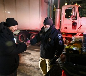 Sub. Minneapolis Police Sgt. Grant Snyder handed a cup of hot chocolate to Dawone Boclair outside the public library in downtown Minneapolis Tuesday night.