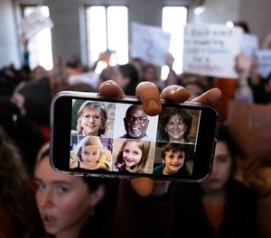 A demonstrator displays a picture of the victims of the Covenant School shooting on a phone inside the Tennessee State Capitol.