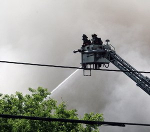 Firefighters work to extinguish flames created by a gas explosion in downtown Durham, N.C. The blast killed two and injured 25, including nine firefighters, on April 10, 2019.