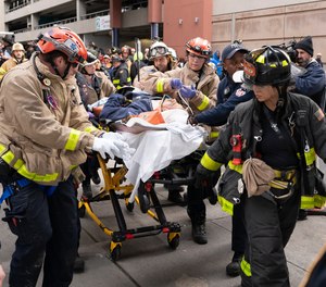 FDNY members transport one of two people who fell down a shaft at 700 Exterior St. to an awaiting ambulance.