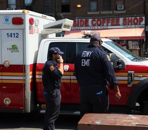 New York City Fire Department EMTs stand outside their truck in the Flatbush neighborhood of the Brooklyn borough.