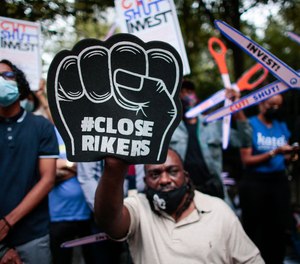 In this photo from September 22,2021, demonstrators call for the closing of the Rikers Island prions as they protest outside the City Hall in New York.
