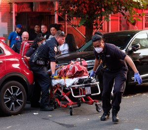 Medics remove a victim following a triple shooting on East 171st Street and College Avenue in the Bronx, New York City, on Sunday, July 5, 2020.