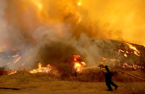 A firefighter battles the Fairview Fire near Hemet, Calif. recently. Experts say more communities will be threatened by catastrophic wildfires if officials don’t scale up mitigation efforts such as prescribed burns.