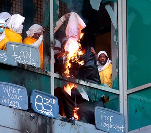 Inmates set bedding materials on fire, dropping them from broken windows at the St. Louis Justice Center.