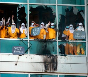 Inmates yell from broken windows at the St. Louis Justice Center, known as the city jail, after fires were set at the facility on Feb. 6.