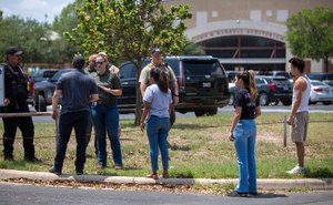 Emergency personnel tell people that Uvalde High School is secure after a school shooting at the nearby Robb Elementary School in Uvalde, Texas.