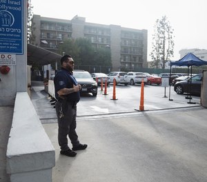 A security guard stands watch in front of a synagogue on Oct. 9, 2023, in Los Angeles, California.