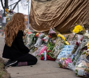 A mourner visits the location where a gunman opened fire at King Soopers grocery store on Monday on March 23, 2021, in Boulder, Colorado. Ten people were killed in the attack.