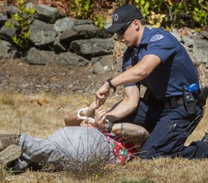 Recruit officer Ryan Rich with the Vancouver Police Department handcuffs “suspect” Don Cornwell, a recruit with the DuPont Police Department, after a mock fight during an academy class at the Washington Criminal Justice Training Center in Burien, Washington on Wednesday, August 18, 2021, where recruits are learning and using less-than-lethal force alternatives.