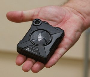 An Akron detective holds an Axon body-worn camera used by Akron police officers.