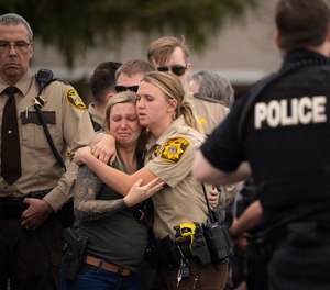 Law enforcement members comforted each other after Deputy Kaitie Leising’s body was carried into a Baldwin, Wisconsin funeral home Sunday afternoon, May 7, 2023.