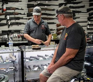 Mike Fiorille, business partner at Get Loaded, serves a customer at the gun store on June 30, 2016, in Grand Terrace, Calif.