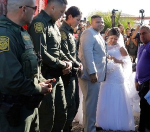 Brian Houston, middle, and Evelia Reyes, right, of Tijuana, are married at the 