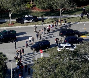 Students are evacuated by police out of Stoneman Douglas High School in Parkland, Fla., after a shooting on Wednesday, Feb. 14, 2018.