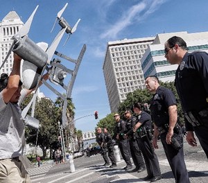 Miguel Guzman flaunts a drone replica in front of Los Angeles Police Department officers after a group blocked downtown traffic, protesting the the LA Police Commission vote to allow the LAPD to use drones, on Tuesday, Oct. 17, 2017.