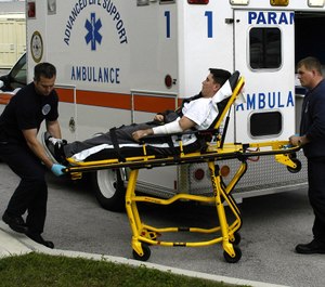 Firefighter-paramedics assist a simulated burn victim during a training drill. (Photo/U.S. Navy by Mass Communication Specialist Seaman Patrick J. Cook)