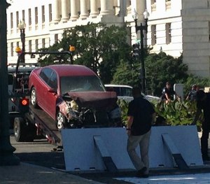 A car is is moved after crashing into a barrier on Capitol Hill in Washington, Friday, July 31, 2015.