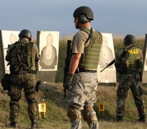 A SWAT firearms instructor and two students on the firing range.