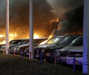 Cars burn at a dealership Tuesday, Nov. 25, 2014, in Dellwood, Mo. A grand jury has decided not to indict Ferguson police officer Darren Wilson in the death of Michael Brown, the unarmed, black 18-year-old whose fatal shooting sparked sometimes violent protests. (AP Photo/Charlie Riedel)
