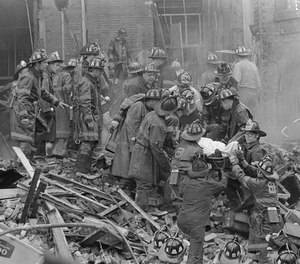 Boston firemen lower one of their fellow firefighters in a litter from a mound of rubble at a corner of the fire-gutted Hotel Vendome in Boston's Back Bay as digging for additional victims continues in the smoky rubble in background, June 17, 1972.