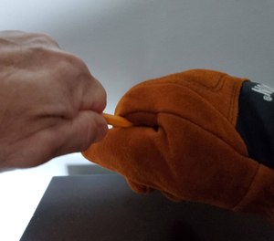 To text dexterity, the author tries to pull a pencil out of the grip of the Victory Structural Fire Glove, without success.