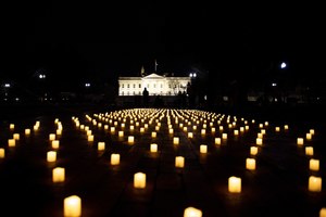 People walk past electric candles displayed in a vigil in Lafayette Park for nurses who died during the COVID-19 pandemic on Jan. 13, 2022, in Washington, D.C.