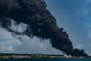 A firefighting helicopter is seen near the oil tank on fire in Matanzas, Cuba, on Saturday, Aug. 6, 2022.