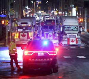 A police vehicle blocks a downtown street to prevent trucks from joining a blockade of truckers protesting vaccine mandates near the Parliament Buildings on Feb. 15, 2022, in Ottawa, Canada.