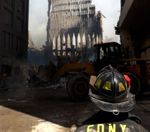 An FDNY firefighter looks up at what remains of the World Trade Center after its collapse during the Sept. 11 terrorist attack.