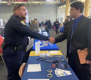 A WVDCR meets with a student a university career fair to discuss careers in corrections.