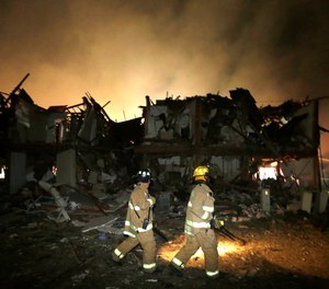 Firefighters walk next to a destroyed apartment complex near a fertilizer plant that exploded earlier in West, Texas, early Thursday morning, April 18, 2013.