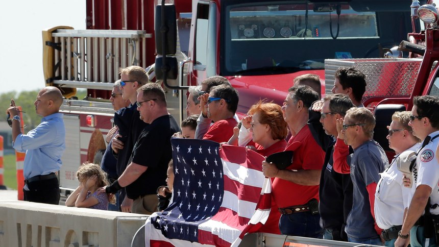 First responders stand on an Interstate 35 overpass to honor two firefighters being transferred from a hospital in Waco, Texas to Hillsboro, Texas Saturday, April 20, 2013, three days after they were injured in an explosion at a fertilizer plant in West, Texas.