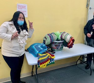 An inmate in the Women in Transition program with the blankets she crocheted in 2021 for a nonprofit that helps people in need of housing.