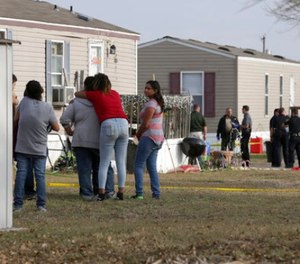 Residents of Pecan Grove Trailer Park in Schertz, Texas, gather to watch Bexar County Deputies investigate near the scene of an officer involved shooting where officers killed a 30 year old female suspect on Thursday, Dec. 21, 2017.