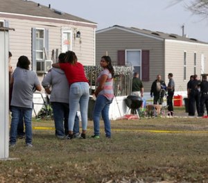 Residents of Pecan Grove Trailer Park in Schertz, Texas, gather to watch Bexar County Deputies investigate near the scene of an officer involved shooting where officers killed a 30 year old female suspect on Thursday, Dec. 21, 2017.