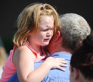 Lilly Chapman, 8, cries after being reunited with her father, John Chapman at Oakdale Baptist Church on Wednesday, Sept. 28, 2016, in Townville, S.C. Students were evacuated to the church following a shooting at Townville Elementary School.