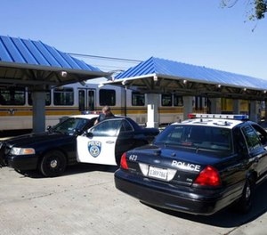 Sacramento Police Officer August Johnson, left, climbs into a patrol car at the Watt Avenue light rail station Wednesday, June 28, 2017, in Sacramento, Calif. (AP Photo/Rich Pedroncelli)