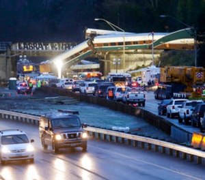 Traffic moves along northbound Interstate 5, left, as southbound lanes are filled with emergency vehicles near the scene of an Amtrak train crash Monday, Dec. 18, 2017, in DuPont, Wash. (AP Photo/Elaine Thompson)
