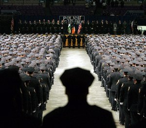 In this file photo of July 13, 2005, New York City Police Academy graduates stand at attention during the presentation of colors at Madison Square Garden in New York.