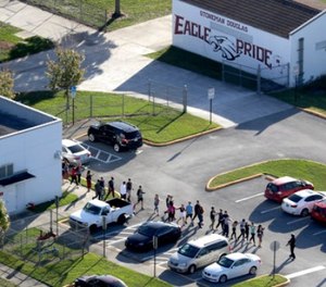 Students are evacuated by police from Marjory Stoneman Douglas High School in Parkland, Fla., on Wednesday, Feb. 14, 2018, after a shooter opened fire on the campus. (Mike Stocker/South Florida Sun-Sentinel via AP)