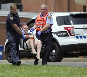 In a May 25, 2016 file photo, emergency personnel carrying a volunteer with simulated injuries is carried during a training exercise for an active shooter at Hopewell Elementary School, in West Chester, Ohio.