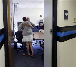 In this July 10, 2015 file photo, volunteer Ruth Cote, facing, hugs Kylee Moriarty, who had voluntarily come to the police for help kicking her heroin addiction.