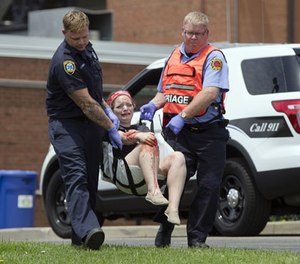 Emergency personnel carry a volunteer with simulated injuries during a training exercise for an active shooter, Wednesday, May 25, 2016, in West Chester, Ohio.