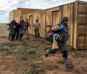 Emergency medical technicians carry a simulated patient as part of the Commando Challenge during the 2016 EMT Rodeo at Melrose Air Force Range, N.M., Aug. 25, 2016.