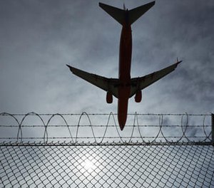 In this May 17, 2016, photo, a sign warns against trespassing as a plane lands at McCarran International Airport in Las Vegas.
